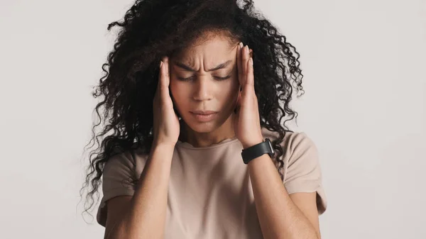 烦躁不安的黑发蓬松的非洲裔美国女人按摩太阳穴时 感到头疼的白色背景 头的痛 — 图库照片