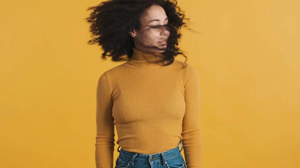 年轻美丽的非洲裔美国女人 乌黑蓬松的头发 头戴橙色的高领毛衣 在五彩缤纷的背景下摇头 — 图库照片