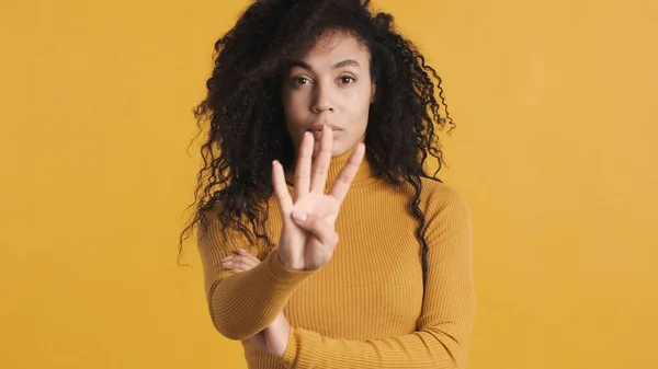 穿着休闲装的美丽的非洲裔美国女人用手指数着五颜六色的背景 通过显示四个手指来计数 — 图库照片