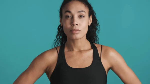 身穿运动胸罩的年轻而美丽的非洲裔美国女人在经历了蓝色背景的锻炼之后看上去很自信 小荡妇 — 图库照片