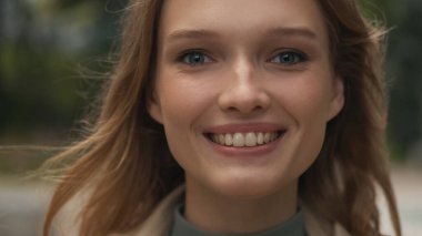 Güzel kız öğrenciyi yakın çekimde kamerada gülümserken mutlu görün. Yüz ifadesi