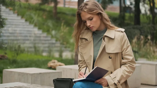 市内公園のベンチで大学の宿題をすることに集中している美しい学生の女の子 スタイリッシュなブロンド女の子勉強屋外 — ストック写真