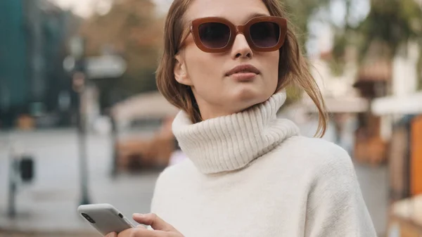 Piękna Dziewczyna Okularach Przeciwsłonecznych Ubrana Biały Przytulny Sweter Patrząc Stylowo — Zdjęcie stockowe