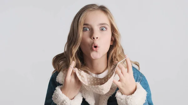 Menina Adolescente Loira Bonita Tirando Máscara Protetora Exalando Câmera Isolada — Fotografia de Stock