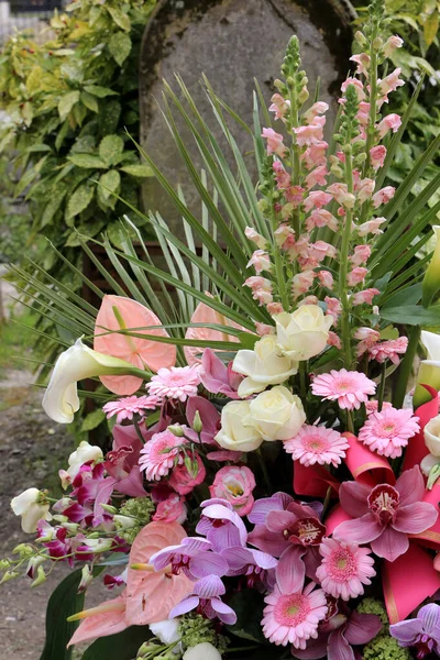 Europe. France. Ile-de-France. Paris. 02/08/2012. This colorful image depicts a bouquet of flowers on a gravestone. Pere Lachaise Cemetery.