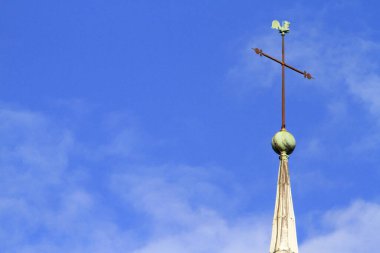 Avrupa. Fransa. Sen ve Marne. Provins. 02 / 08 / 2012. Bu renkli görüntü mavi gökyüzüne karşı bir rüzgar gülü ve çan kulesinde bir haç tasvir ediyor.. 