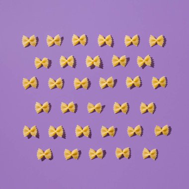 Ev yapımı farfalle 'ın yaratıcı tasarımı. Eğlenceli ve parlak yemek konsepti. Mor arkaplanda İtalyan makarnası.