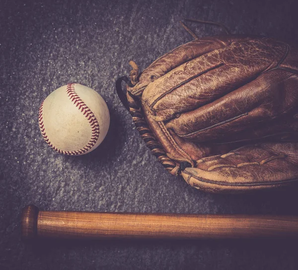 old baseball glove vith ball and bat