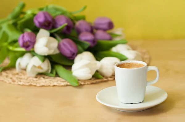 Tulips on the table with cup of caffee — Stock Photo, Image