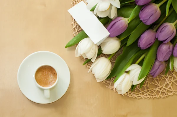 Tulipas na mesa com xícara de café Fotografia De Stock