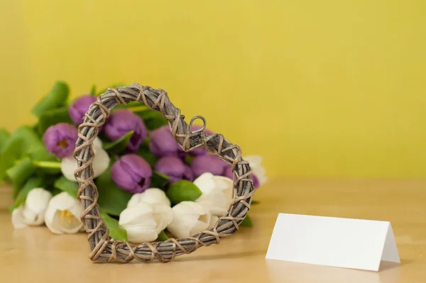 Белый и фиолетовый тюльпаны на столе с сердцем — стоковое фото