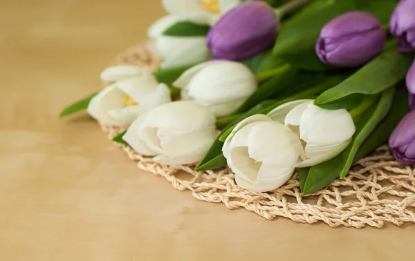 Tulipanes blancos y violetas sobre la mesa — Foto de Stock