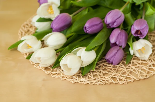Białe i fioletowe tulipany na stole — Zdjęcie stockowe