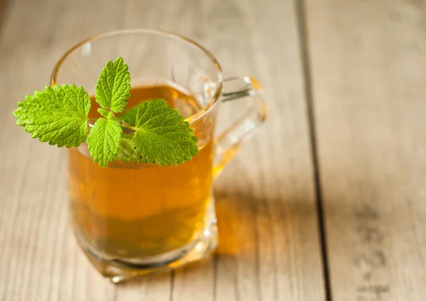 Tazza di tè con menta sul tavolo di legno — Foto Stock