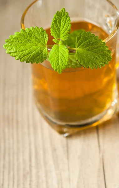 Tazza di tè con menta sul tavolo di legno — Foto Stock