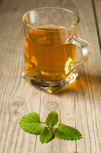 Tazza di tè con menta sul tavolo di legno — Foto Stock