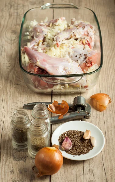 Κρέατος κουνελιού ακατέργαστη roaster με κύμινο κρεμμύδι και το σκόρδο σε ξύλινο τραπέζι vintage — Φωτογραφία Αρχείου