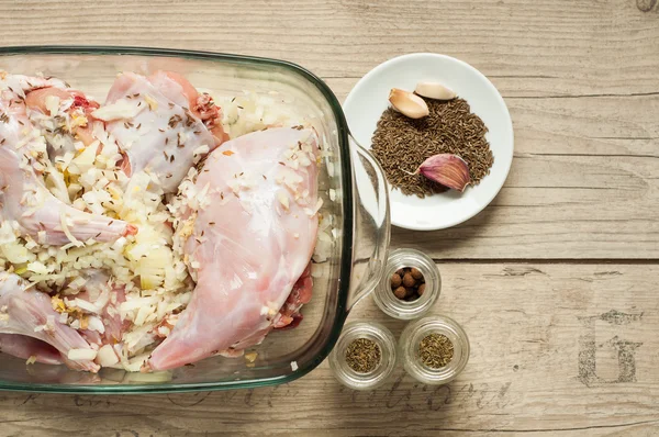 Carne crua de coelho na torradeira com cominho de cebola e alho na mesa vintage de madeira Imagem De Stock