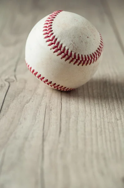 Beisebol velho em fundo de madeira e altamente close-up — Fotografia de Stock