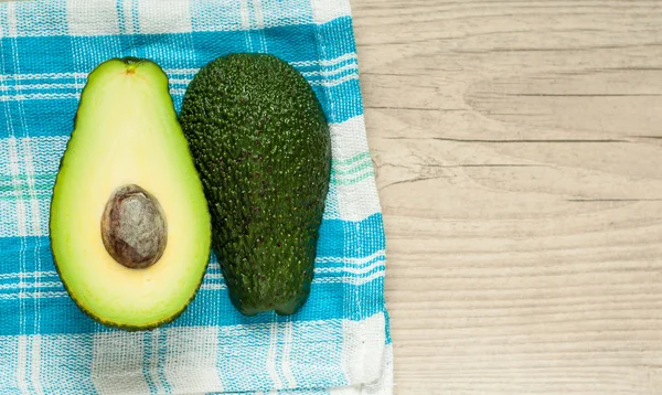 Halved avocados on rustic wooden background — Stock Photo, Image