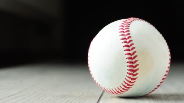 Rotazione palla da baseball su pavimento in legno — Video Stock