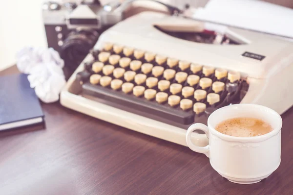 An old typewriter on old wooden table with coffee and old camera — Stock Photo, Image