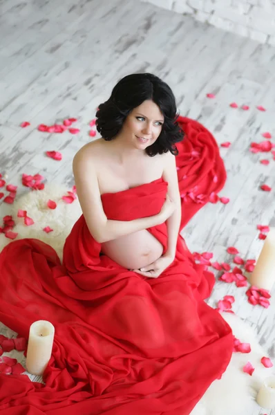 Retrato de uma bela mulher grávida em xale de chiffon vermelho — Fotografia de Stock