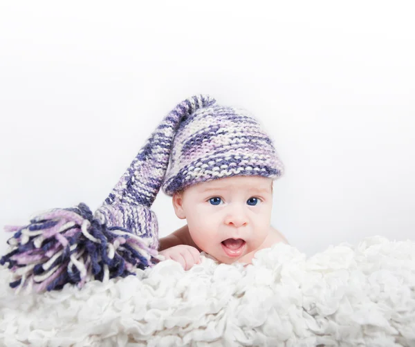 Nouveau-né en chapeau long drôle coloré regardant la caméra — Photo