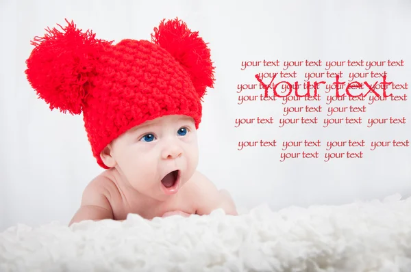 Новорожденный в красной шляпе смотрит в камеру — стоковое фото