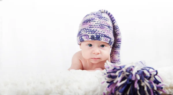 Nouveau-né en chapeau long drôle coloré regardant la caméra — Photo