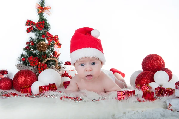 Słodkie dziecko w kapelusz Świętego Mikołaja z choinki za — Zdjęcie stockowe