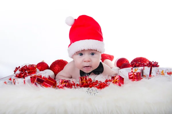 Lindo bebé en el sombrero de Santa y corbata de lazo negro cerca del árbol de Navidad —  Fotos de Stock