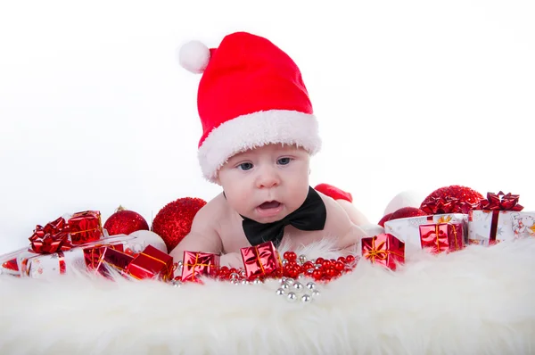 Schattige baby in Santa's hoed en zwarte strikje in de buurt van de kerstboom — Stockfoto