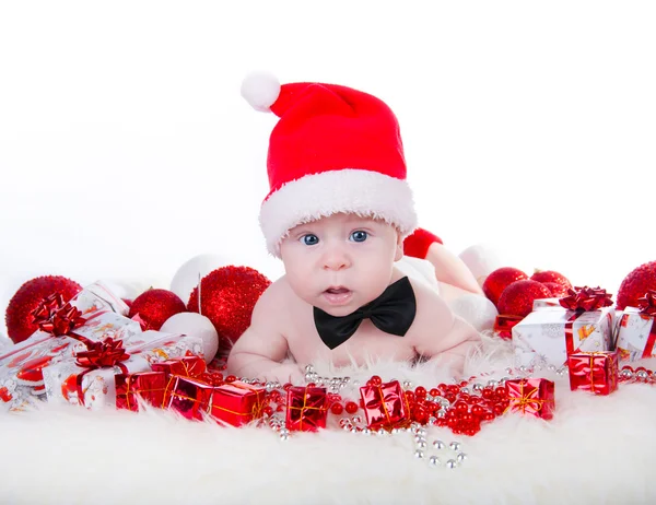 Lindo bebé en el sombrero de Santa y corbata de lazo negro cerca del árbol de Navidad —  Fotos de Stock