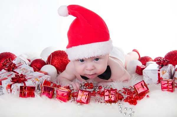 Lindo bebé en el sombrero de Santa y corbata de lazo negro cerca del árbol de Navidad —  Fotos de Stock