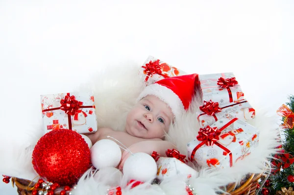 Funny baby verkleed in santa claus hoed op lichte feestelijke achtergrond — Stockfoto