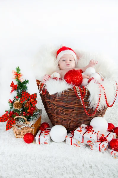 Funny baby klädd i jultomten hatt på festliga ljus bakgrund — Stockfoto