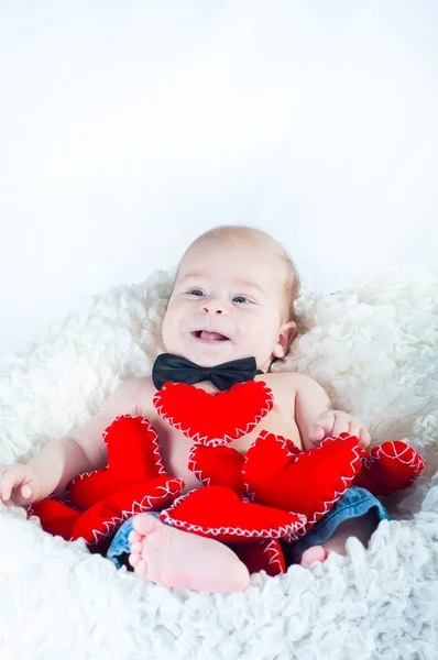 Pequeno menino bonito em gravata arco e com coração vermelho — Fotografia de Stock