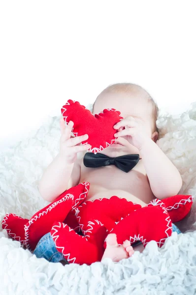 Маленький красивый мальчик в бабочке и с красным сердцем — стоковое фото