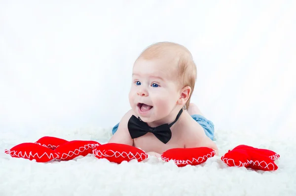 Liten vacker pojke i fluga och med rött hjärta — Stockfoto