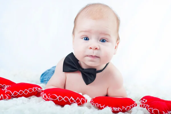 Pequeño niño hermoso en pajarita y con corazón rojo — Foto de Stock