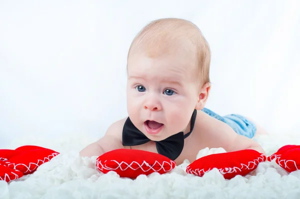 Kleiner schöner Junge in Fliege und mit rotem Herz — Stockfoto