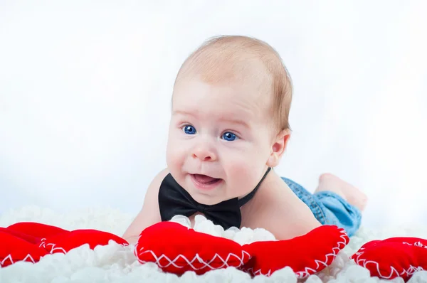 Pequeno menino bonito em gravata arco e com coração vermelho — Fotografia de Stock