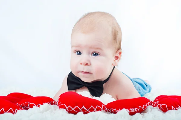 Pequeño niño hermoso en pajarita y con corazón rojo —  Fotos de Stock