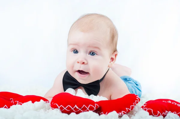 Liten vacker pojke i fluga och med rött hjärta — Stockfoto