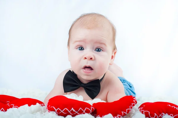 Pequeño niño hermoso en pajarita y con corazón rojo — Foto de Stock