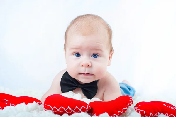 Pequeno menino bonito em gravata arco e com coração vermelho — Fotografia de Stock