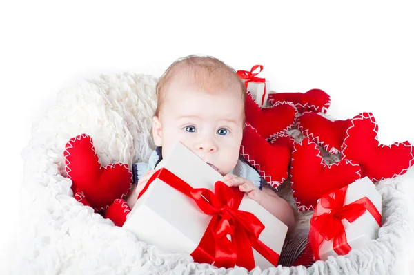 Niño con una caja de regalo y corazones — Foto de Stock