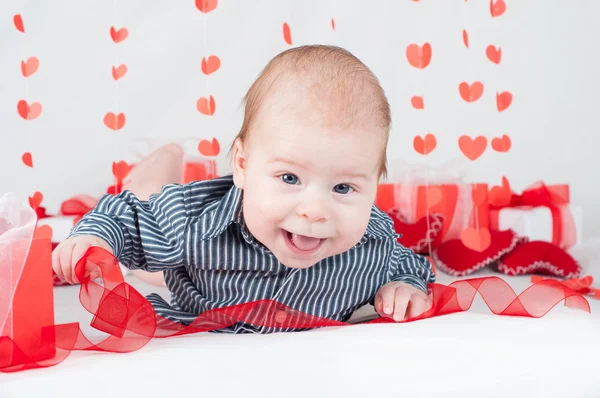 Niño con una caja de regalo y corazones. Concepto de San Valentín — Foto de Stock