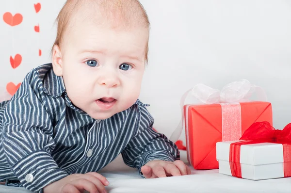 Niño con una caja de regalo y corazones. Concepto de San Valentín — Foto de Stock